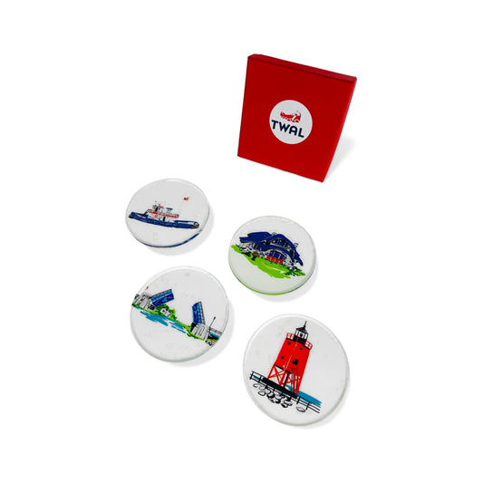 Set of four round clear lucite coasters by TWAL with the Wendy Anne tug boat, Earl Young House, Charlevoix Drawbridge and South Pier Lighthouse, beside the red TWAL gift box