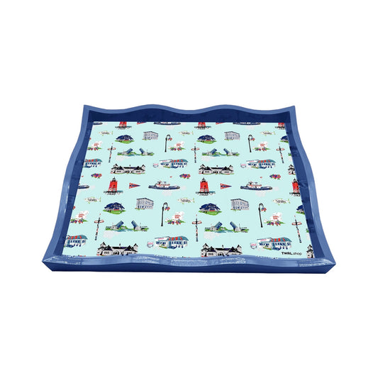 Large blue lacquer tray by TWAL with a scalloped edge, printed with the Charlevoix toile pattern of local landmarks, including the South Pier Lighthouse, drawbridge, tug boats and cottages, on light blue, Charlevoix Pop Art Collection